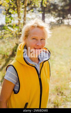 Porträt einer Frau mittleren Alters in einem Park an einem sonnigen Tag Stockfoto