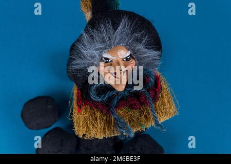 Epiphanisches Urlaubskonzept. Hexe Befana und Kohlenteile für unartige Kinder auf blauem Hintergrund. Italienische Epiphanietage-Tradition. Stockfoto