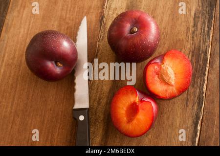 Frische ganze und halbierte Pflaumen Stockfoto