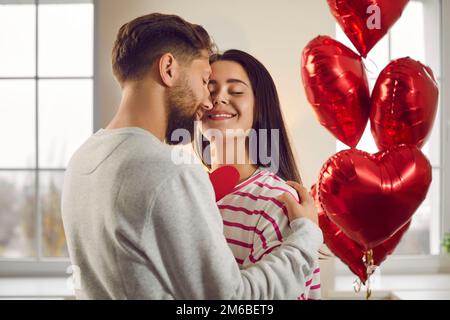 Verliebter Mann und verliebte Frau feiern den Valentinstag und machen sich romantische Geschenke Stockfoto