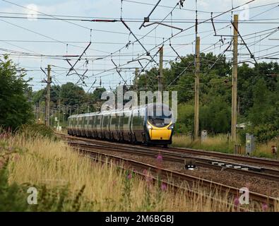 Ein elektrischer Zug von Avanti West Coast Pendolino fährt an der Kreuzung Balshaw Lane der West Coast Main Line vorbei und fährt nach London Stockfoto