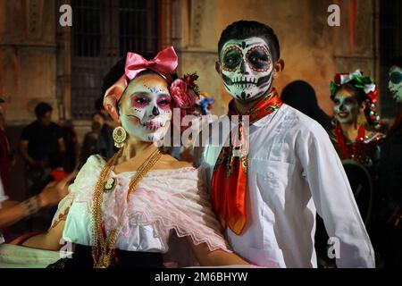 Teilnehmer, die als Catrina und Catrín gekleidet sind, nehmen an der Catrina-Parade zum Todestag (Día de los Muertos) in Mérida, Yucatan, Mexiko Teil Stockfoto