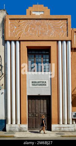 Eine Frau geht an der markanten Art déco-Fassade der Yucatan-Bibliothek in Merida Centro, Yucatan, Mexiko vorbei Stockfoto
