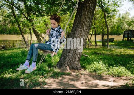 Ein Mädchen, das auf einer Seilschaukel reitet Stockfoto