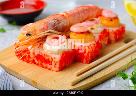 Sushi Rolls mit Langoustine und Shrimps, gebackene Sushi Rolls Seafood and Crab, Sahnekäse auf hellem Hintergrund Stockfoto