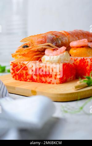 Sushi Rolls mit Langoustine und Shrimps, gebackene Sushi Rolls Seafood and Crab, Sahnekäse auf hellem Hintergrund Stockfoto