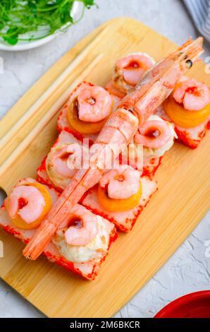 Sushi Rolls mit Langoustine und Shrimps, gebackene Sushi Rolls Seafood and Crab, Sahnekäse auf hellem Hintergrund Stockfoto
