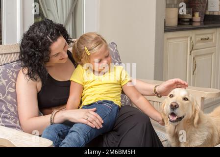 Mutter und Tochter mit Golden Retriever auf der Veranda Stockfoto