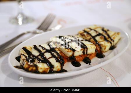 Gebratener Käse mit Tomaten und Balsamico-Essig Stockfoto