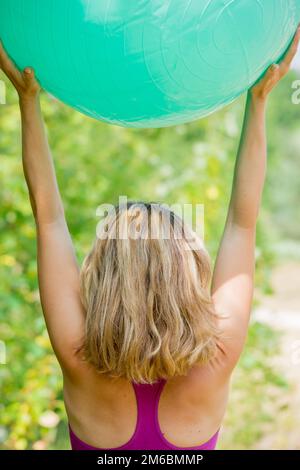 Blonde Frau, die die Yoga-Pose in den Bergen vorführt Stockfoto