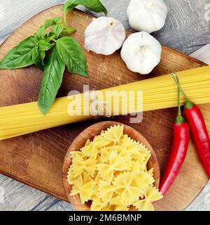 Rohe Spagetti und Farfalle Nudeln auf dem Tisch Stockfoto