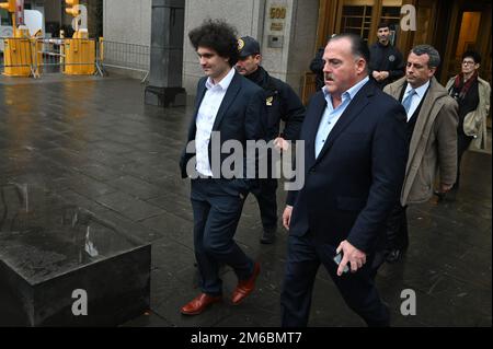 New York, USA. 03. Januar 2023. Samuel Bankman-Fried (l) hat sich nach der Berufung auf „nicht schuldig“ beim Verlassen des US District Court in Manhattan am 3. Januar 2023 gesehen. Bankman-Fried wird angeklagt, Kunden und Anleger seiner Kryptowährungsbank FTX betrogen zu haben und die Gelder für den persönlichen Gebrauch und für Schulden seines Hedgefonds zu verwenden. FTX meldete im November 2022 Konkurs an. (Foto: Anthony Behar/Sipa USA) Guthaben: SIPA USA/Alamy Live News Stockfoto