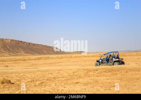 Merzouga, Marokko - 24. Februar 2016: Rückansicht auf blauem Polaris RZR 800 mit seinen Piloten in der marokkanischen Wüste bei Merzouga. Merzouga i. Stockfoto
