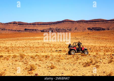 Merzouga, Marokko - 21. Februar 2016: Zwei Piloten Frauen des Geländewagens RZR warten auf Hilfe in der marokkanischen Wüste bei Merzou Stockfoto