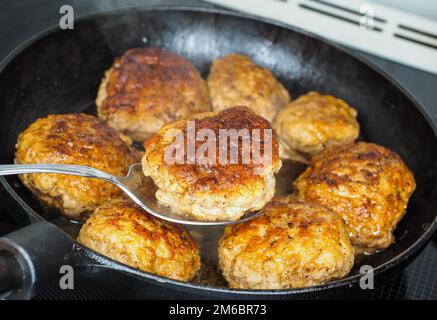 Braten, hausgemachte Frikadellen in Schwarz eiserne Pfanne, in der feinen Brühe Stockfoto