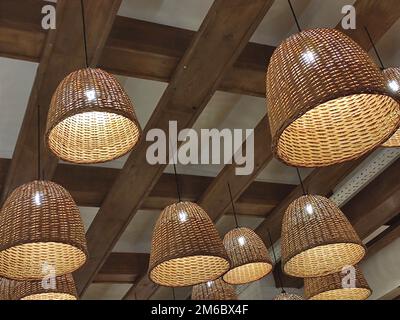 Elektrische Lampen Hintergrund. Viele Lampen in Körben hängen an einer Holzdecke Stockfoto