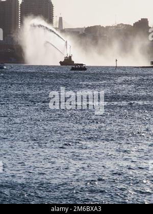 Feuerwehrboot, das Wasser im Hafen spritzt Stockfoto