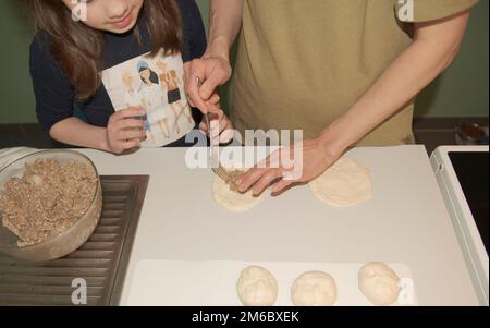 Mom lehrt Tochter, Kuchen zu backen Stockfoto