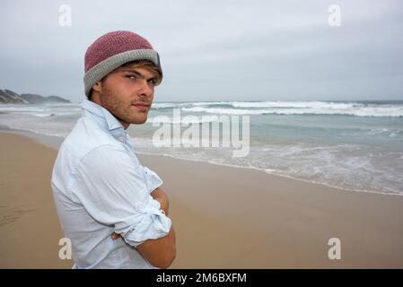 Junger Mann am bewölkten Tag am Meer Stockfoto