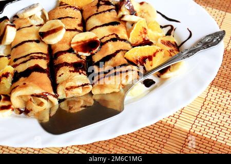 Pfannkuchen gefüllt mit Grieß, Bananen und Orangen getränkt dunklen Schokolade Stockfoto