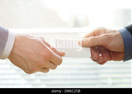 Geschäftsleute, die Austausch von Visitenkarte im Büro mit Sonnenschein Stockfoto