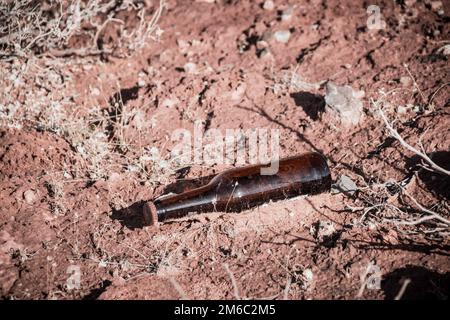 Eine Glasflasche, weggeworfen in der Natur, Verschmutzung der Wüste Stockfoto