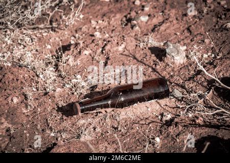 Eine Glasflasche, weggeworfen in der Natur, Verschmutzung der Wüste Stockfoto