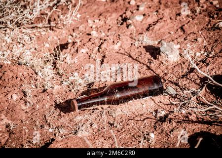 Eine Glasflasche, weggeworfen in der Natur, Verschmutzung der Wüste Stockfoto