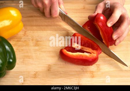 Hände des Mannes schneiden Paprika in der Küche eine Mahlzeit zuzubereiten, für das Mittagessen. Erhöhte Ansicht. Stockfoto