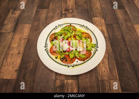 Es handelt sich um einen kalten Salat, dessen Zutaten sind: Geriebener Kabeljau, italienischer grüner Pfeffer und roter Pfeffer in Stücke geschnitten, Zwiebeln, Oliven und Tomaten. Mit Oli würzen Stockfoto