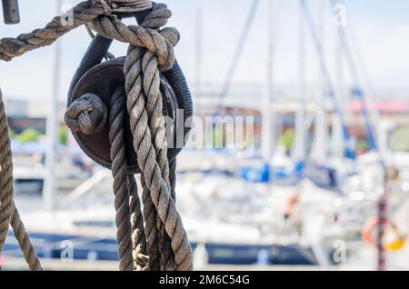 Auf der alten Segelboot vor dem Hintergrund der modernen Yachten Rigging Stockfoto