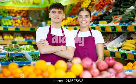 Junge Männer und Frauen, die in der Obstabteilung des Supermarkts vor der Kamera lächeln Stockfoto