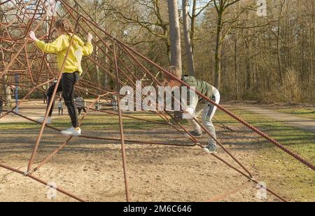 Junge und Mädchen auf einem сhildren-Spinnennetz Stockfoto