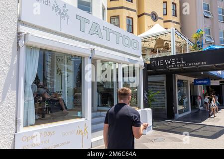 Bondi Beach Ink Tattoo Shop mit Leuten, die Tätowierungen auf ihren Körper angebracht haben, Bondi, Sydney, NSW, Australien Stockfoto