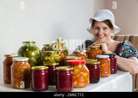 Hausfrau mit Gemüse in Dosen und Beeren in Dosen Stockfoto