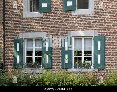 Hasselt, Limburg, Belgien 21-07-2021. Ein Teil eines alten Gebäudes am Eingang zum öffentlichen Park - Fensterläden, Fenster Stockfoto