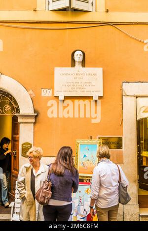 Touristen schauen sich Gemälde unter Gedenktafel an Stockfoto