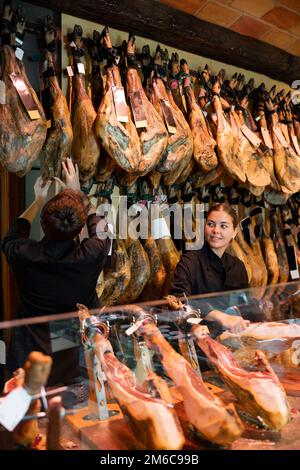 Junge weibliche und männliche Verkäufer arrangieren einen Pyjon an der Theke in der Metzgerei Stockfoto