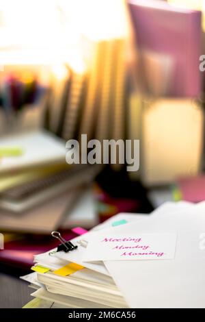 Sitzung Montag Morgen; Stapel von Dokumenten. Arbeiten oder Studieren an unordentlichen Schreibtisch. Stockfoto