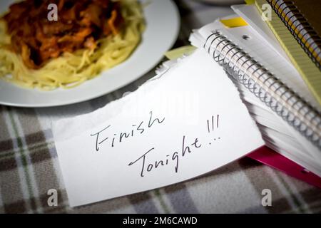 Beenden heute Abend; Stapel von Dokumenten. Arbeiten oder Studieren während des Essens. Stockfoto