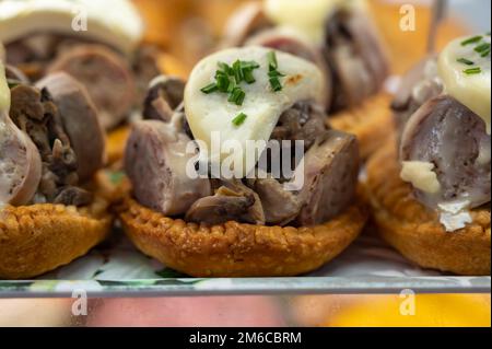 Französische Mini-Quiche-Torte mit Ziegenkäse und traditioneller französischer Wurst Andouillette von Troyes in der Bäckerei aus nächster Nähe Stockfoto