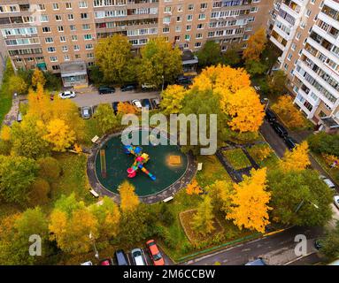 Kinderspielplatz im Hof des Hauses im Herbst in Moskau, Russland Stockfoto