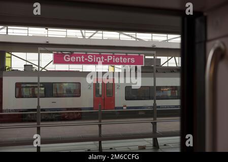 Gent, Flämische Region — Belgien. 22-08-2021. Stationsname Gent-Sint-Pieters auf dem Schild. Blick vom Waggon Stockfoto