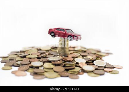 Kleines rotes Auto auf Münzen. Stockfoto