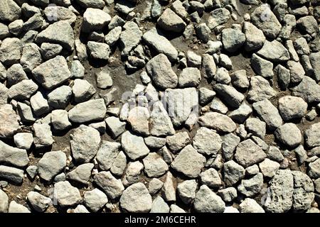 Felsen auf der Straße. Feine Steinstruktur. Stockfoto