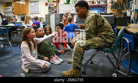 Senior Airman Hason Kimble, 75. Sicherheitsgeschwader, spricht mit Schülern der Hill Field Elementary School während einer Heroes Reading Veranstaltung am 22. April 2022. Das „Heroes Reading“-Programm ist eine jährliche Veranstaltung, die vom Verbindungsbüro der Hill AFB School in Zusammenarbeit mit örtlichen Grundschulen durchgeführt wird. Die Veranstaltung findet jedes Frühjahr in Verbindung mit dem Monat des Militärkindes im April statt. In diesem Jahr wird das Programm nach einer Unterbrechung aufgrund der COVID-19-Pandemie wieder aufgenommen. Im Laufe des Monats werden Freiwillige von Airmen drei Schulen besuchen und mehr als 1.400 Schülern vorlesen. Stockfoto