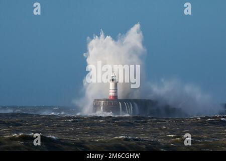 Wellenbrecher über dem Leuchtturm Stockfoto