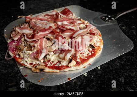 Pizza vorbereitet zum Backen Stockfoto