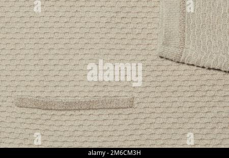 Die Konsistenz eines Strickpulvers mit einem Bruchteil eines Ärmels und einer Tasche Stockfoto