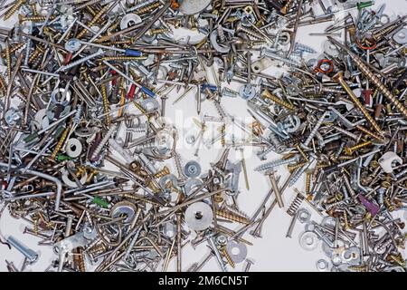 Viele Zahnräder, Schrauben, Schrauben und Stimmungen auf weißem Hintergrund. Stockfoto